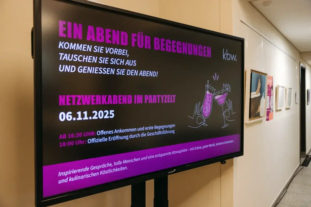 Screen mit der Aufschrift "Netzwerkabend im Partyzelt" im Foyer