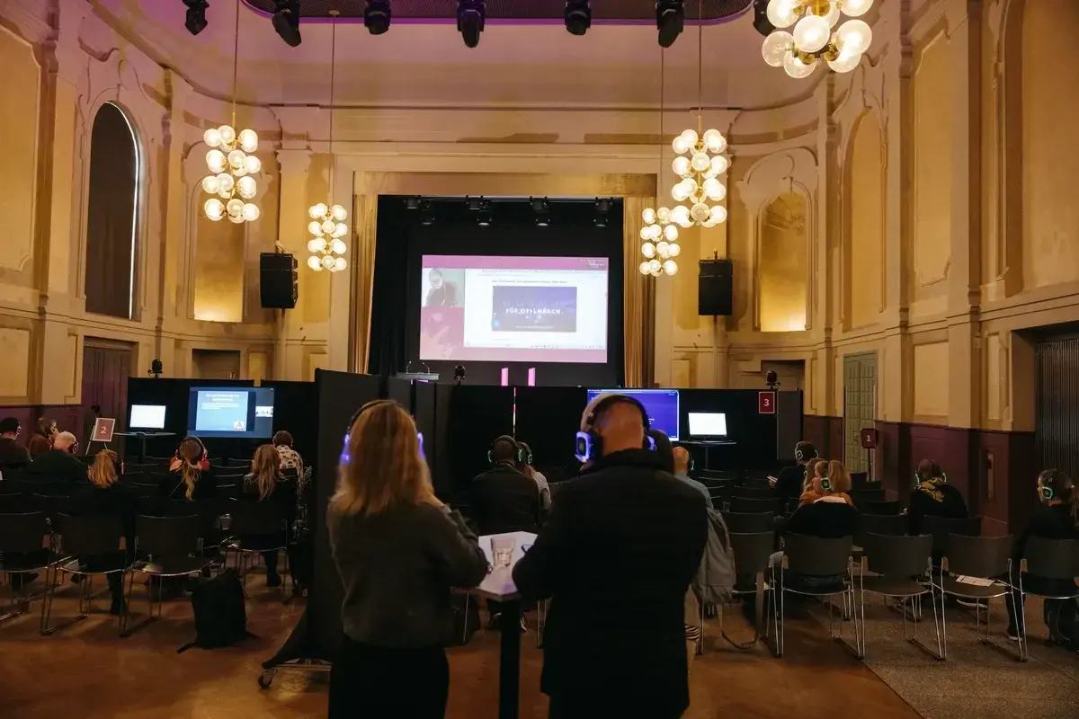 Blick in den großen Saal während einer Live-Ubertragung dreier Sessions in drei separierten Bereichen