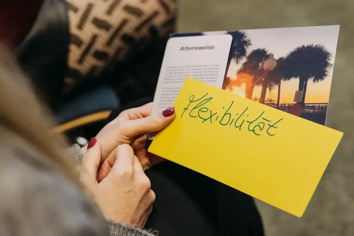 Teilnehmerin hält ein Notizkärtchen mit der Aufschrift "Fleibilität" in der Hand